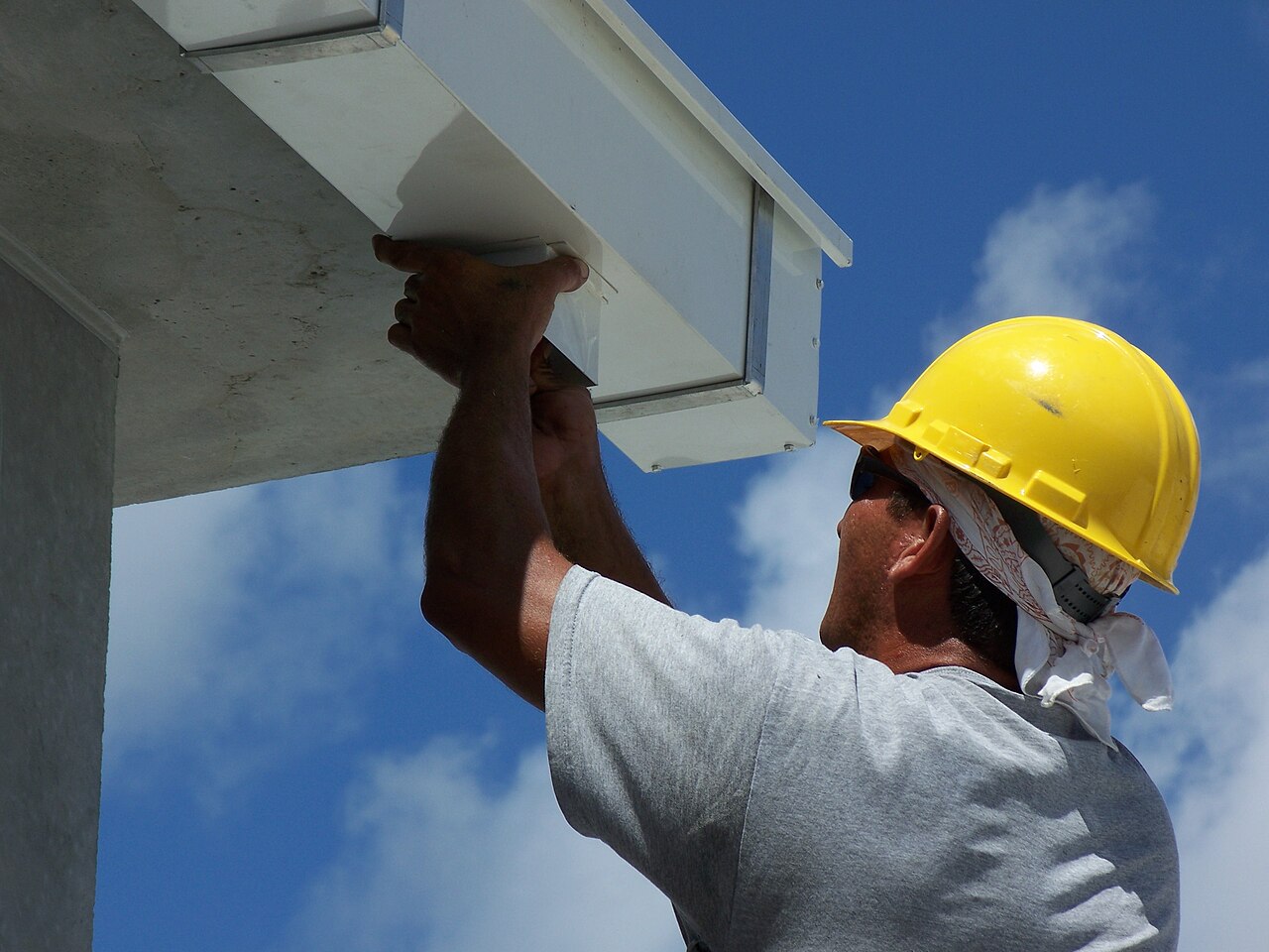 Professional installing a new rain gutter on a home